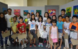 A photo of kids with their artworks