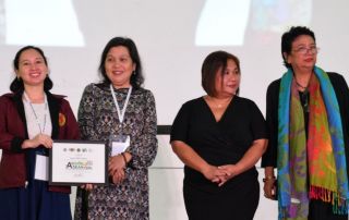 Ms. Anna Canas-Llamas (L), UPOU employee, receives certificate for winning the honorable mention for Best Experimental Film, given by (L-R) Dr. Arminda Santiago, ASEANnale Director of the ASEANnale 2018 Film and Multimedia Competition, Atty. Lily Milla, CHED Director, and Dr. Grace Javier Alfonso, ASEANnale 2018 Chair of the Organizing Committee.