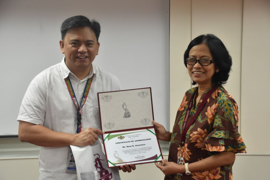 Mr. Hans R. Alcantara (L), Director of Civil Service Commission CSC Field Office – UP, receives the certificate of appreciation for conducting an orientation on the implementing rules and regulations of RA 11032 from UPOU Vice Chancellor for Finance and Administration, Dr. Jean A. Saludadez .