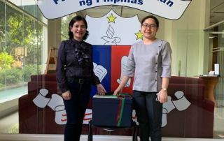 Ms. Jennifer Belen-Bunao, UPOU LIbrarian,(L) hands over UPOU donations to Ms. Melody Madrid (R), Chief Librarian of the Collection Development Division of the National Library of the Philippines