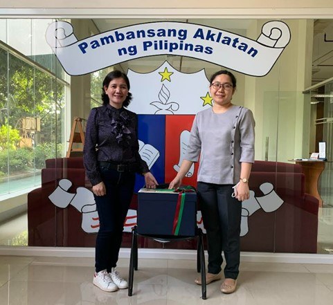 Ms. Jennifer Belen-Bunao, UPOU LIbrarian,(L) hands over UPOU donations to Ms. Melody Madrid (R), Chief Librarian of the Collection Development Division of the National Library of the Philippines