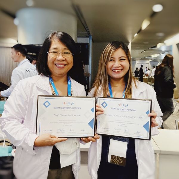 Prof. Consuelo Habito (left) and Asst. Prof. Mari Anjeli Crisanto (right) holding their certificates of completion of the 12th Assessor Training Workshop for AUN-QA Programme Assessment (Tier 2 Training)
