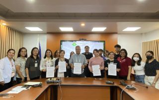 UPOU and CvSU officials and staff pose with a copy of the MOA signed for collaborative advancement in utilizing the Filipinized LMS.