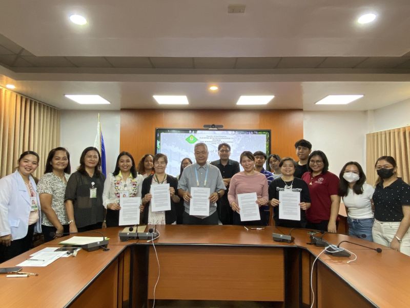 UPOU and CvSU officials and staff pose with a copy of the MOA signed for collaborative advancement in utilizing the Filipinized LMS.