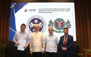 UP Open University officials and Department of Finance Officials pose on stage with a copy of the signed memorandum of agreement.