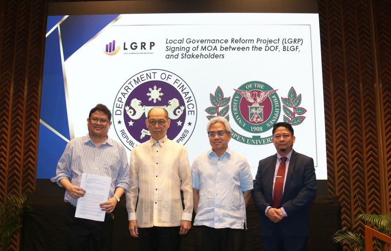 UP Open University officials and Department of Finance Officials pose on stage with a copy of the signed memorandum of agreement.