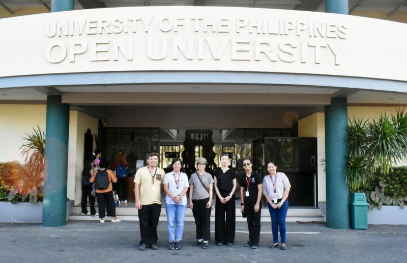 (from left to right) Dr. Figueroa, Dr. Serrano, Ms. Nagayama, Asst. Prof. Fukuda, Mr. Mangubat, and Ms. Suarez at the front of UPOU Main Building
