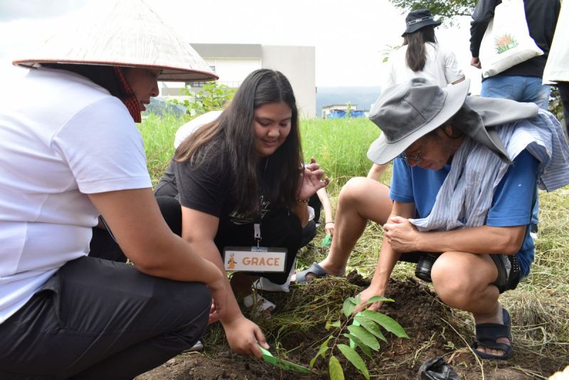 (from left to right) FMDS Dean Serrano, Ms. Mary Grace Campollo, and Dr. Wong planting one out of the five atis seedlings during the commemorative planting ceremony