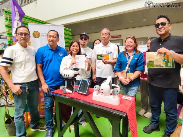 Los Baños Mayor, Hon. Neil Nocon (center), and LGU officials, with UPOU staff members at the UPOU booth. 