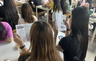Overseas Filipinos in Taiwan browse through the UPOU brochure during the UP VINTA Learning Caravan