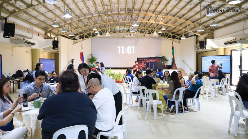 Participants of the Mini Faculty Conference huddle in groups for the World Cafe Method.