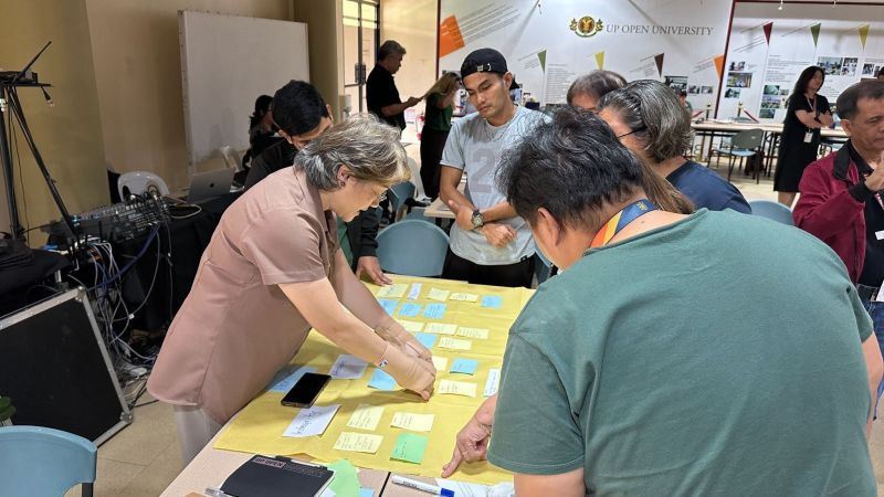 Prof. Tiffany Adelaine G. Tan assists participants in refining their group outputs as they translate the UP values of Honor and Excellence into meaningful workplace behaviors during the WAVES session.